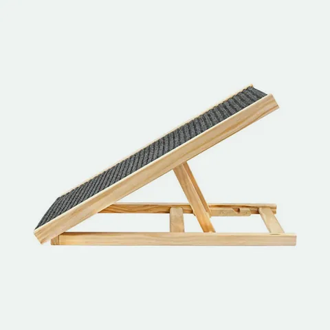 Folding wooden dog ramp with a grey ridged carpet top standing on its fold-out legs