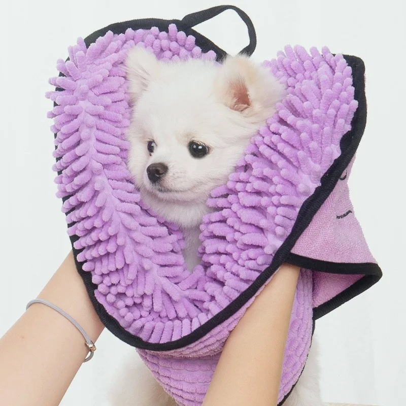 Small white dog wrapped in a lilac chenille drying towel