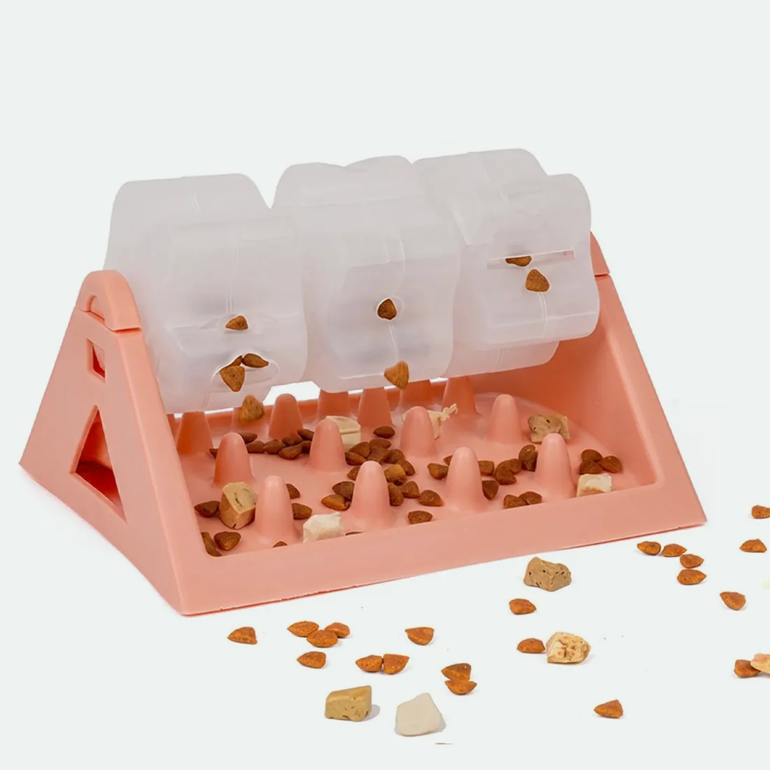 Pink rotating treat feeder with kibble in the drums and on the base